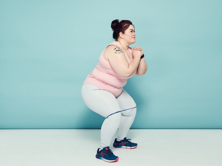 Woman in a squat position with a resistance band