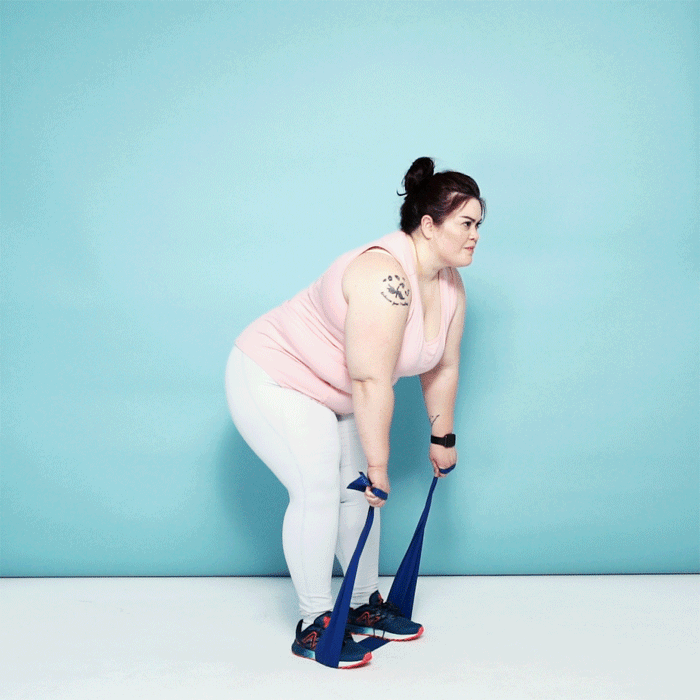 Woman demonstrating a hamstring curl with a resistance band